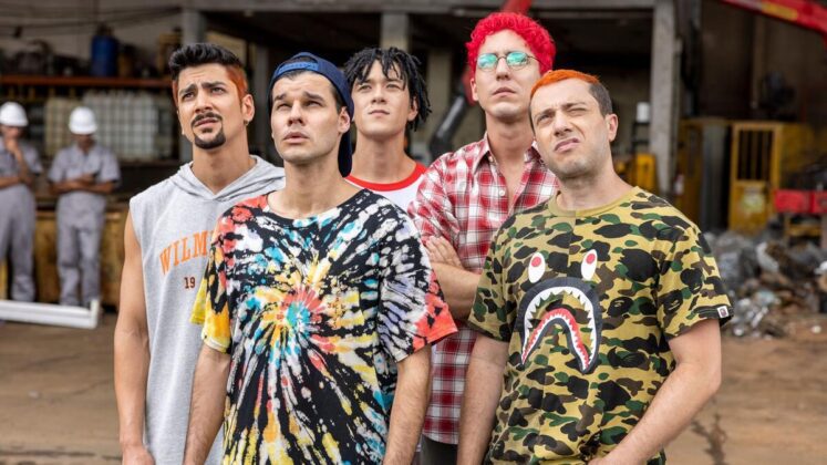 5 jovens com camisetas coloridas olham para cima observando algo grandioso.