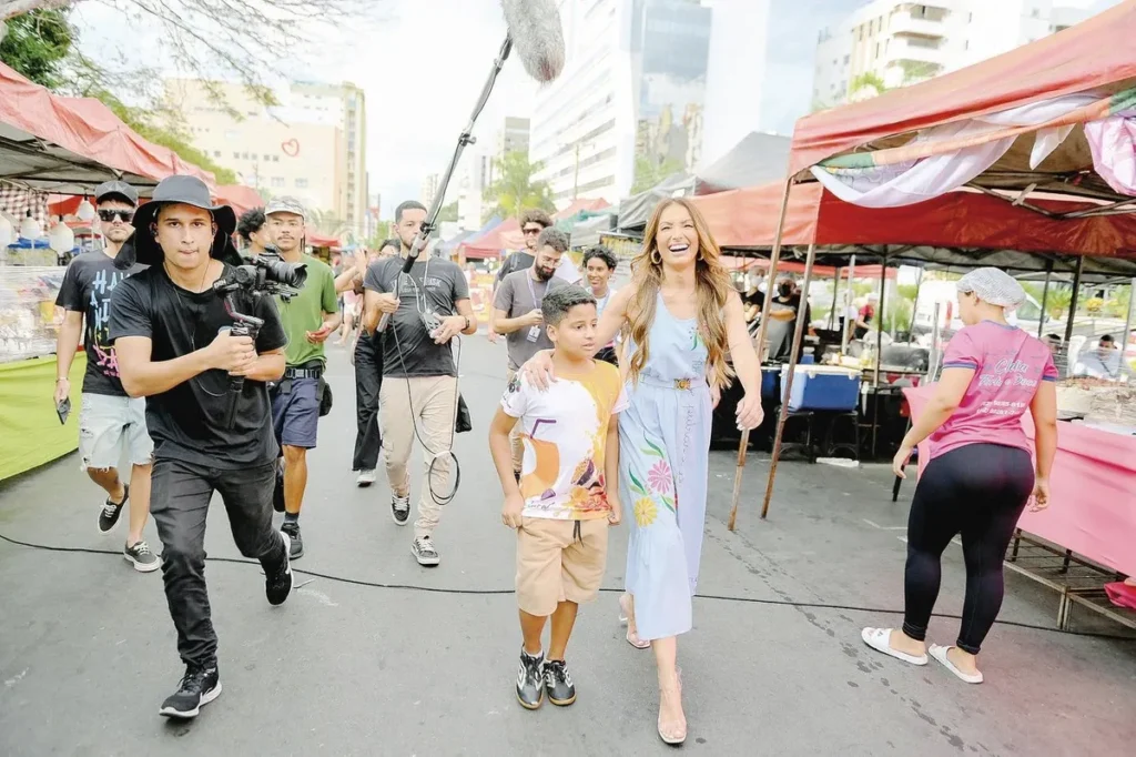 Patrícia Poeta aparece de vestido azul em uma feira de Goiânia.
