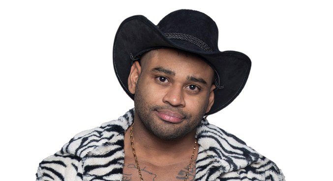 cezar black está de chapéu marrom e camisa com estampa de zebra