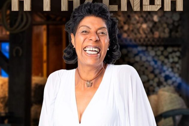 Márcia Fu esta sorrindo usando camisa branca e colar