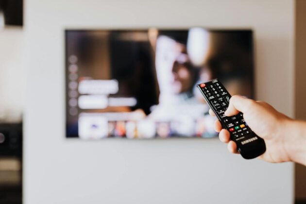person pressing the button of a remote control