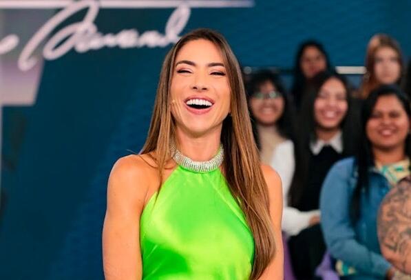 Patrícia Abravanel de vestido verde no meio do auditório do Programa Silvio Santos