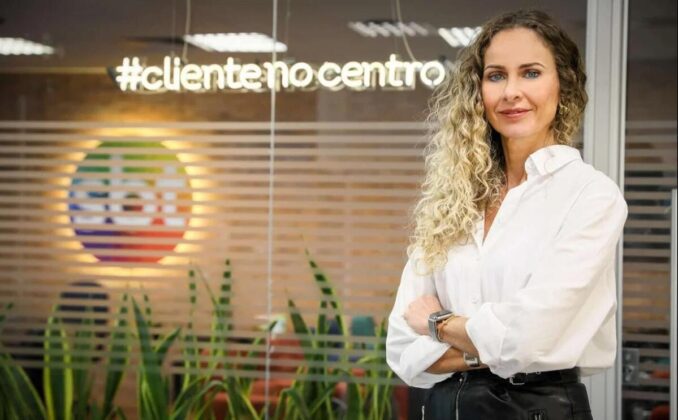 Luciana Valério à frente do logo do SBT