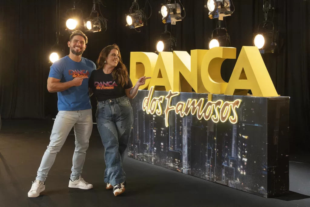 Tati Machado e professor à frente do logo do Dança dos Famosos