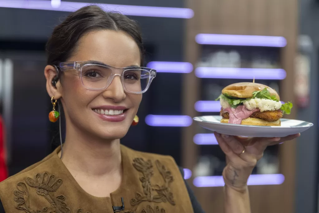 Renata Vanzetto segura hambúrguer no cenário do Chef de Alto Nível