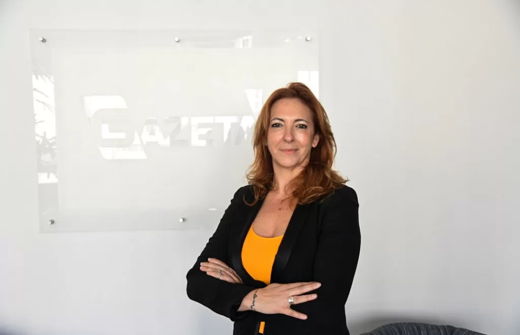 Juliana Algañaraz à frente do logo da gazeta