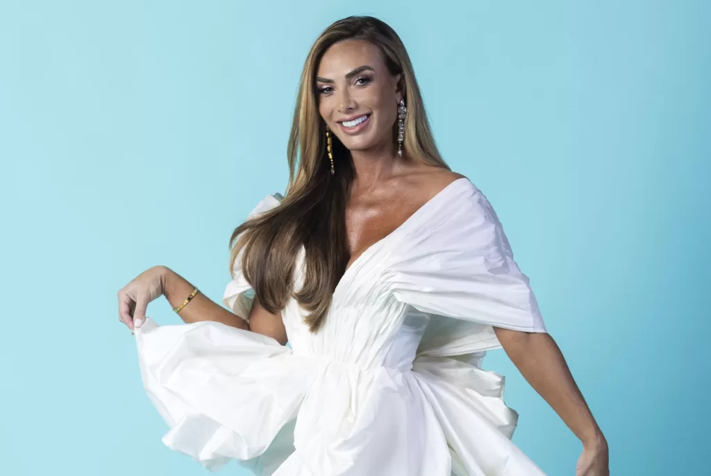 Nicole Bahls à frente de um fundo azul