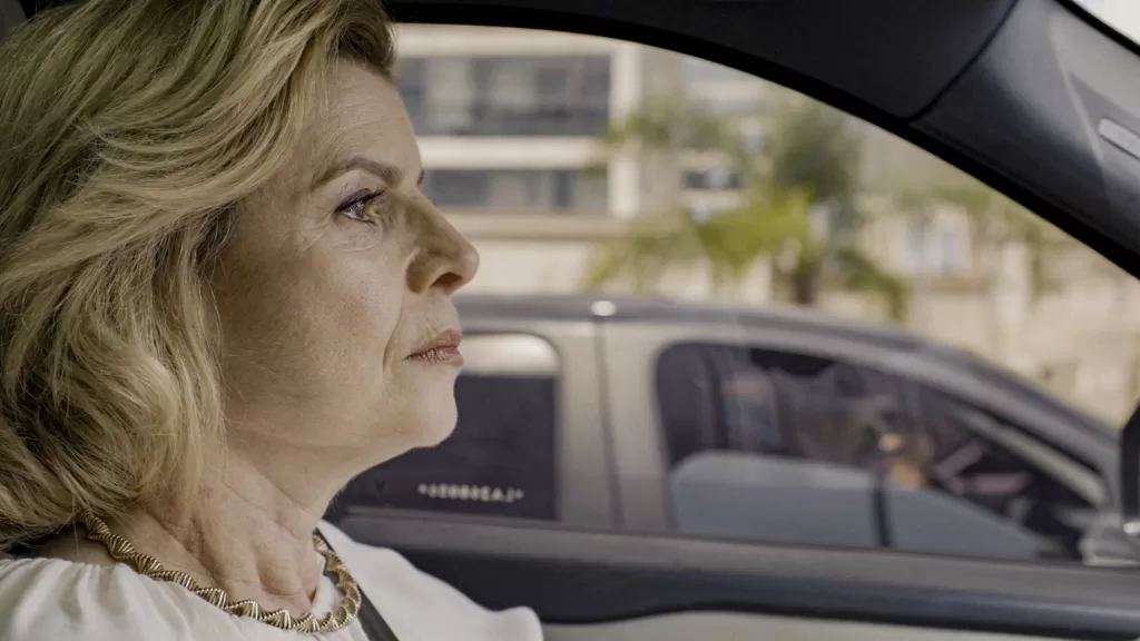 Odete Roitman no carro e um atirador no outro veículo