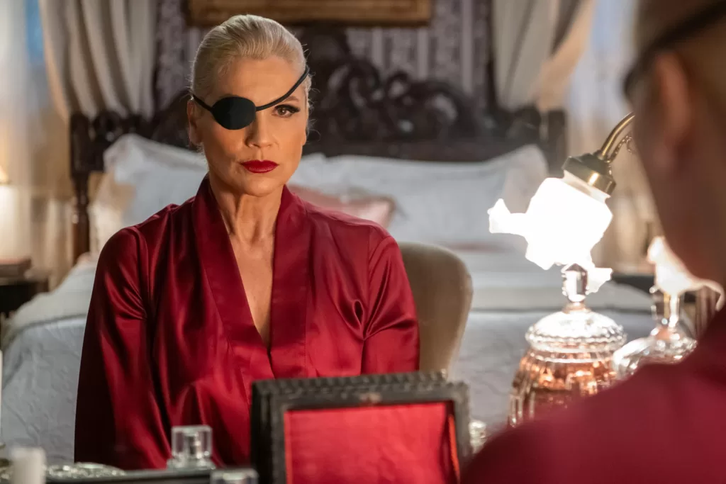 Flávia Alessandra como Sandra em nova fase de Êta Mundo Melhor. Ela vestida de vermelho com tapa olho preto