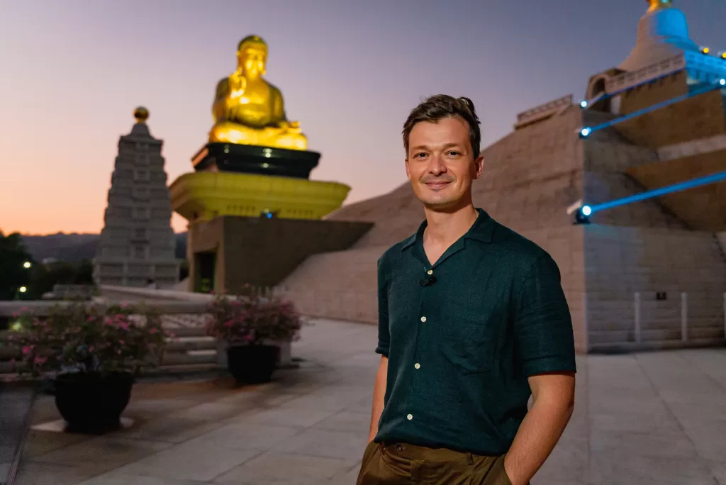 Felipe Santana à frente de uma estátua de Buda