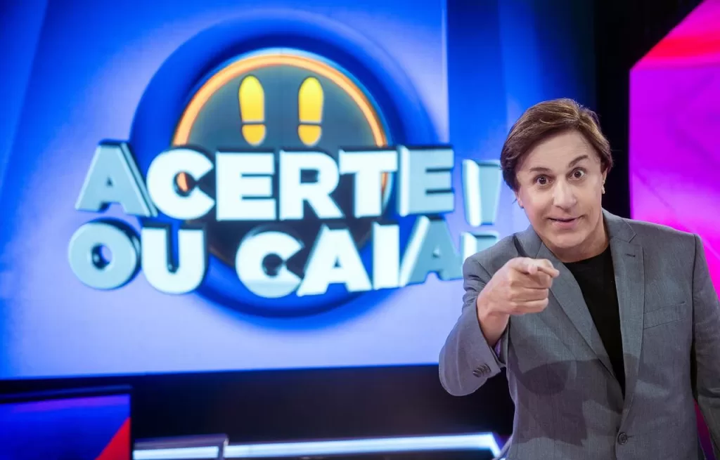 Tom Cavalcante à frente do logo do Acerte ou Caia