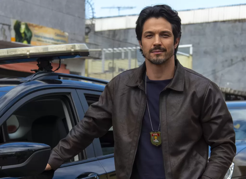 Paulinho ao lada da viatura de polícia