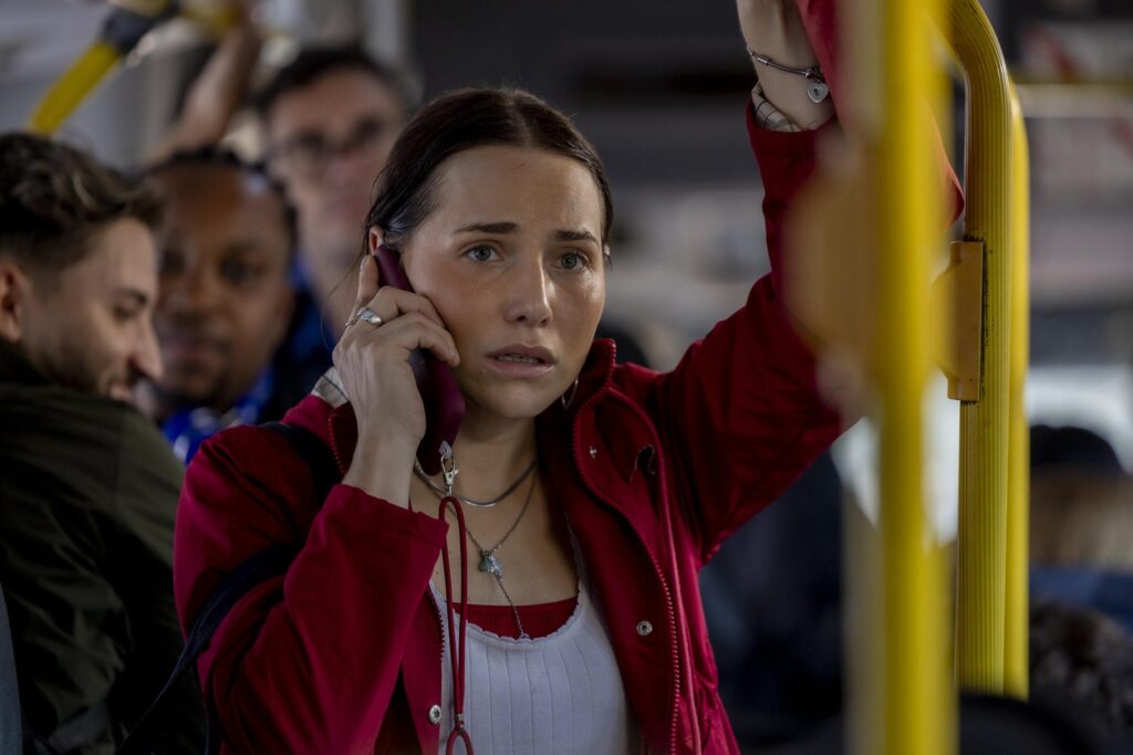 Adriana fala ao celular dentro do ônibus