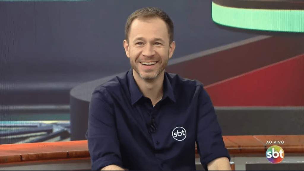 Tiago Leifert com camisa do SBT no cenário da coa