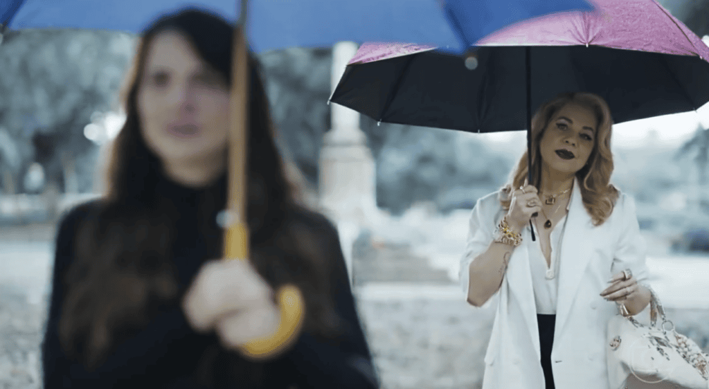 Pilar segura guarda-chuva vermelho e Adriana azul.