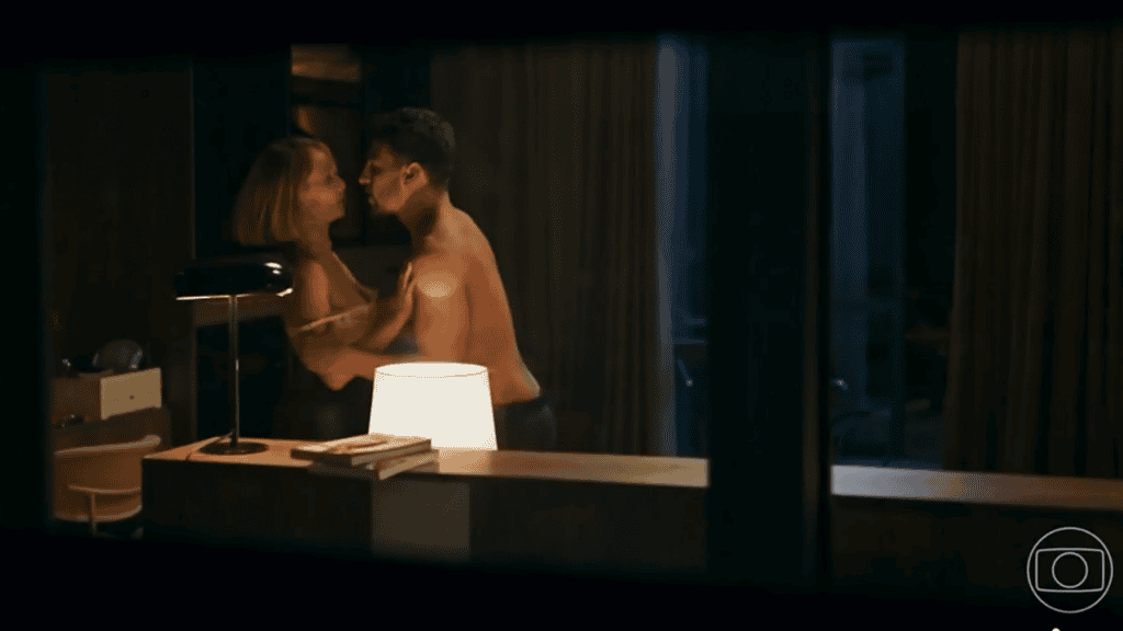 Dora e André sem camisa se beijam