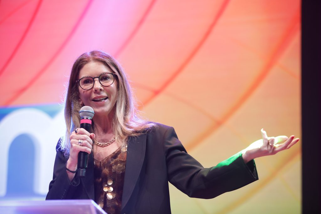 Daniela Beyruti à frente do logo do SBT